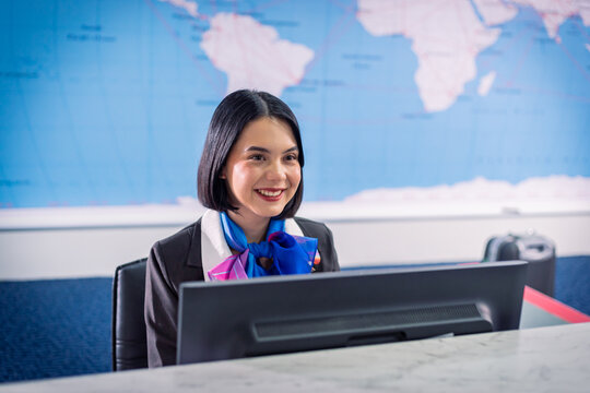 Gorgeous Asian Airline Ground Staff Smiles At The Check-in Counter At The Airport. During A Covid-19 Pandemic Around The World.