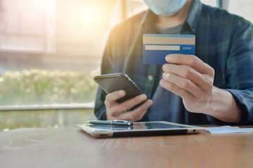 Close up hand holding mobile phone shopping online with credit, Man stay at home protect coronavirus covid19