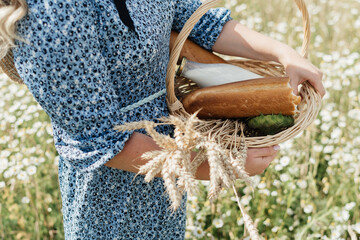 basket with bread, milk and wheat ears in hands of young woman. High quality photo
