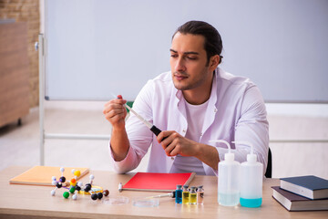 Young male chemistry teacher in the classroom