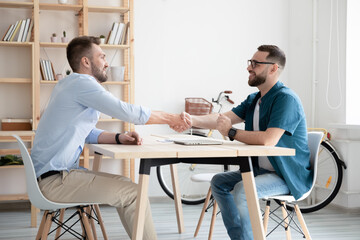 Smiling businessmen shake hands close deal after successful interview in office. Happy employer handshake candidate or business partner make agreement or get acquainted at meeting. Employment concept.