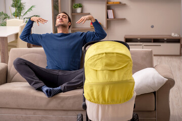 Young male contractor looking after baby at home