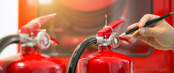 Fire engineering checking pressure gauge indicator chemical liquid level of fire extinguishers tank in the building concepts of prevent case for emergency and safety rescue and fire training.