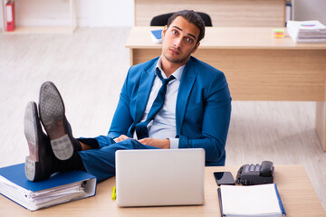 Young businessman employee unhappy with excessive work in the of