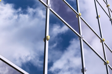Fototapeta premium Architectural detail of the facade with multiple reflections of other buildings and the sun. Modern building. Architecture background