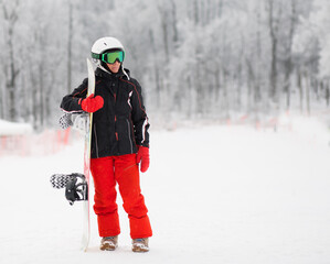 Fototapeta na wymiar Senior woman with snowboard stand in winter mountain