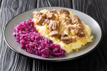 Dutch cuisine beef and onion stew served with mashed potatoes and red cabbage close-up in a plate on the table. horizontal