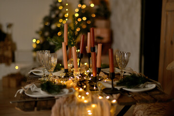 Table dinner set with candles for a new year party. Christmas table decoration.