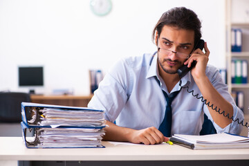 Young male employee unhappy with excessive work in the office
