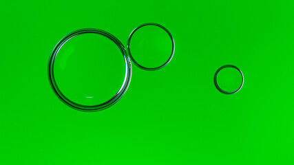 Trzy połyskliwe krople oleju na na zielonym jaskrawym tle