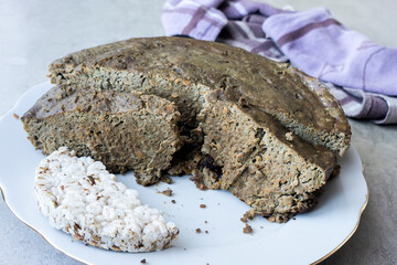 Sliced homemade liver pate and bread on a plate with a towel in the background
