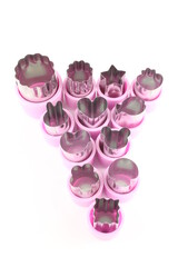 Mini fruit vegetable and cookie cutters isolated on a white background with copy space