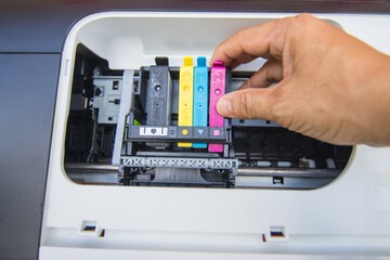 Technicians are install setup the ink cartridge of a inkjet printer the device of office automate...