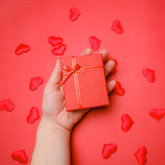 Valentine day concept. Female hand holding red gift box. Valentine gift.