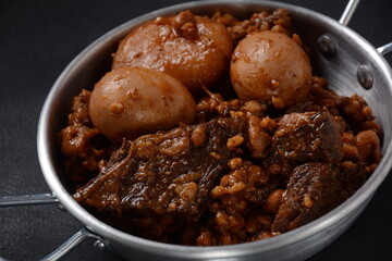 Jewish cuisine - Cholent (Hamin).Traditional main dish for Jewish Shabbat lunch, slow cooked beef Stew with potato, beans, barleys, wheat and brown eggs in a metal casserole