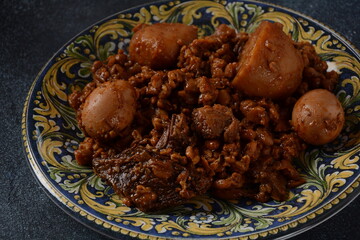 Jewish cuisine - Cholent (Hamin).Traditional main dish for Jewish Shabbat lunch, slow cooked beef Stew with potato, beans, barleys, wheat and brown eggs in a plate