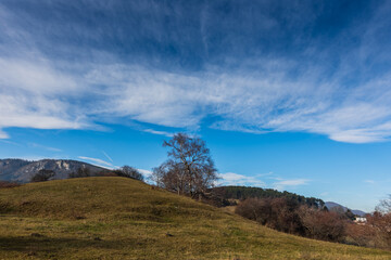 soft clouds and blue sky with hilly landscape