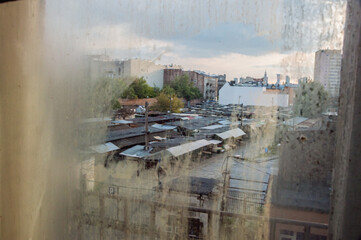 Widok za zabrudzonej szyby na Bazar R&oacute;życkiego, z jednej, z Praskich Kamienic.