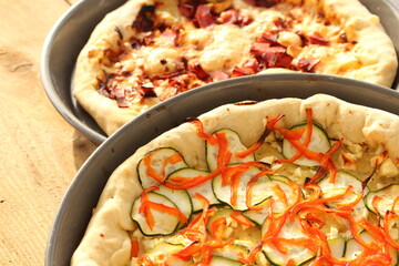 two different pizzas with cheese, ham and one vegetarian
