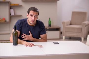 Young sick male alcoholic suffering at home