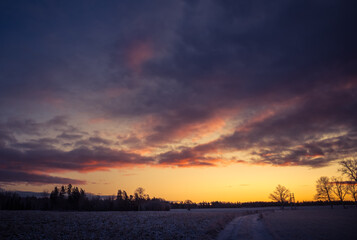 A beautiful, bright, colorful landscape of a winter sunrise. Bright sky and first snow. Winter scenery of a Northern Europe during the sunrise.