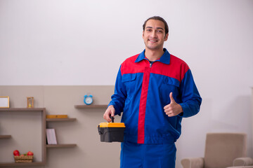 Young male contractor repairing furniture indoors