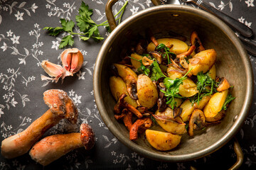 Fried potatoes with mushrooms and onions at home in a frying pan