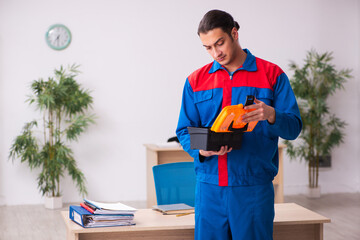 Young male contractor repairing furniture in the office