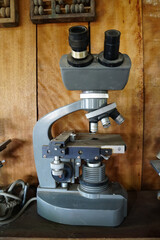 old microscope on wooden vintage background.
