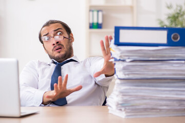 Young businessman unhappy with excessive work in the office