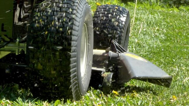 The hole where the grasses are coming out of the lawn mower while moving forward cutting grasses in Estonia