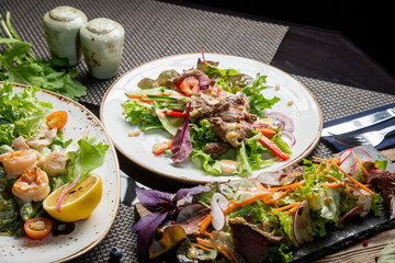 Meat salad with fresh vegetables. Table setting in the restaurant