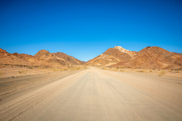 Road trip on gravel roads between mountains to Ai-Ais, Namibia.