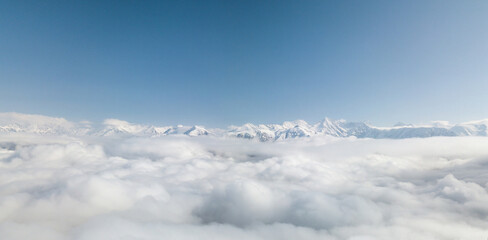 Aerial view from above of clouds. Rosa Khutor Ski Resort, mountains covered by snow in Krasnaya...