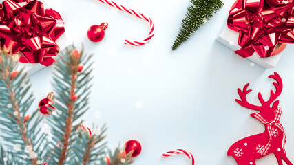 Xmas sale. White gift with scarlet bow, red balls and winter tree, candy in Christmas decoration on white background for greeting card. Christmas, winter, new year concept.