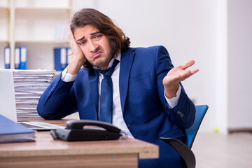 Young male employee unhappy with excessive work