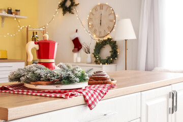 Coffee pot with Christmas decor on table in kitchen