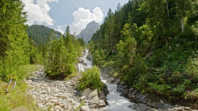 Timelapse waterfall in the mountains. Water flowing between rocks in the forest. Simmenfall waterfalls. Simmental. Bernese Oberland. Canton Bern. Switzerland.