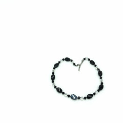 Women's necklace made of black and transparent faceted beads of different sizes. Metal clasp. Isolated on white background.