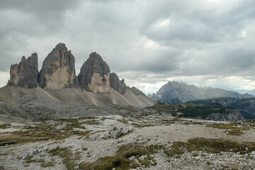 Obraz premium A panoramic capture of the famous Tre Cime di Lavaredo (Drei Zinnen) and surrounding mountains in Italian Dolomites. The mountains are surrounded by thick clouds. A lot of landslides. Serenity
