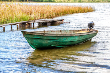 Naklejka na ściany i meble Landscape with plastic fishing motor boat on the lake