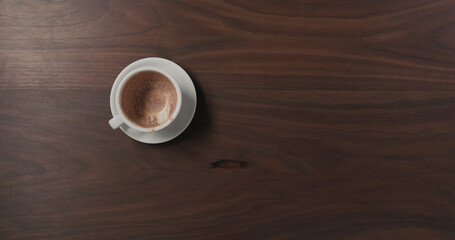 Top view left overs from hot chocolate in white cup on walnut wood table