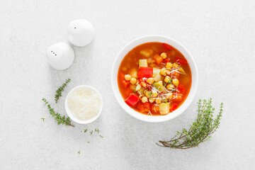 Tuscan tomato chickpea soup with various vegetables, thyme and parmesan cheese, top view