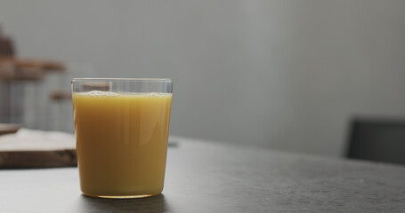 orange juice in thin glass on kitchen countertop