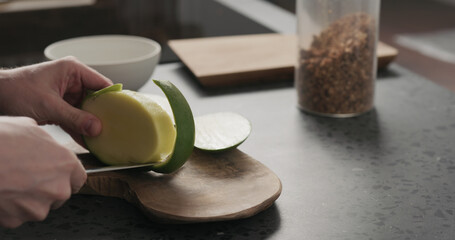 man cut green mango on olive wood board