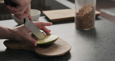 man cut green mango on olive wood board