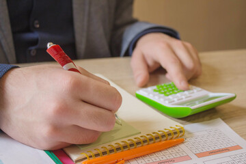 A business person sitting and counting money on a wooden table. business finance, expenses concept