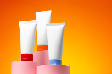 Blank white cosmetic container against orange background