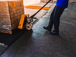 Worker driving forklift loading shipment carton boxes goods on wooden pallet at loading dock from...