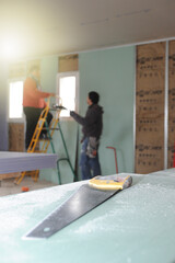 Workers put up gypsum plasterboard panel